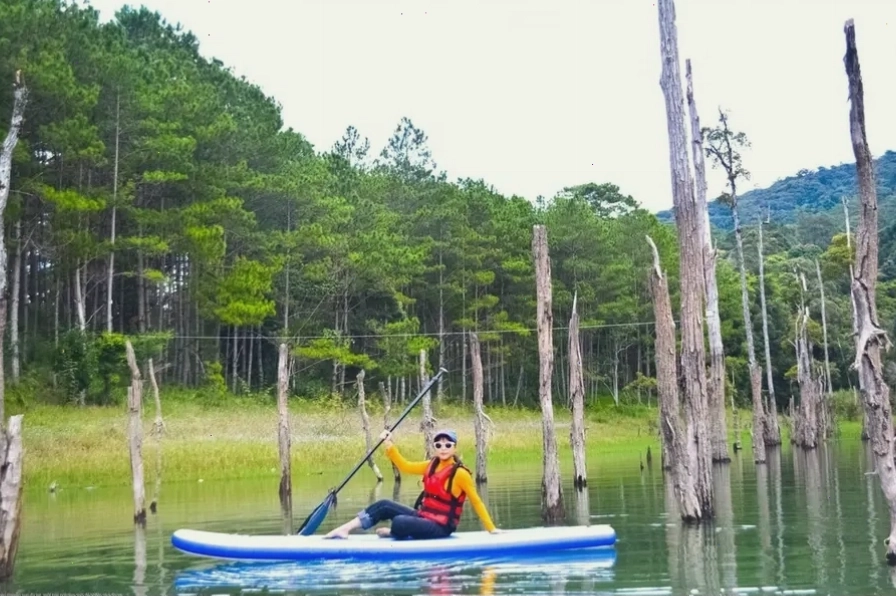 Du khách đang chèo thuyền Kayak trên mặt hồ Tuyền Lâm trong xanh