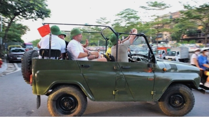 Hướng dẫn viên giải thích lịch sử thành phố trên một chuyến tham quan ngắm cảnh bằng xe Jeep