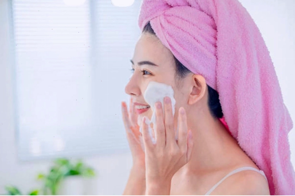 Người phụ nữ đang sử dụng sữa rửa mặt, chú ý đến độ pH của sản phẩm