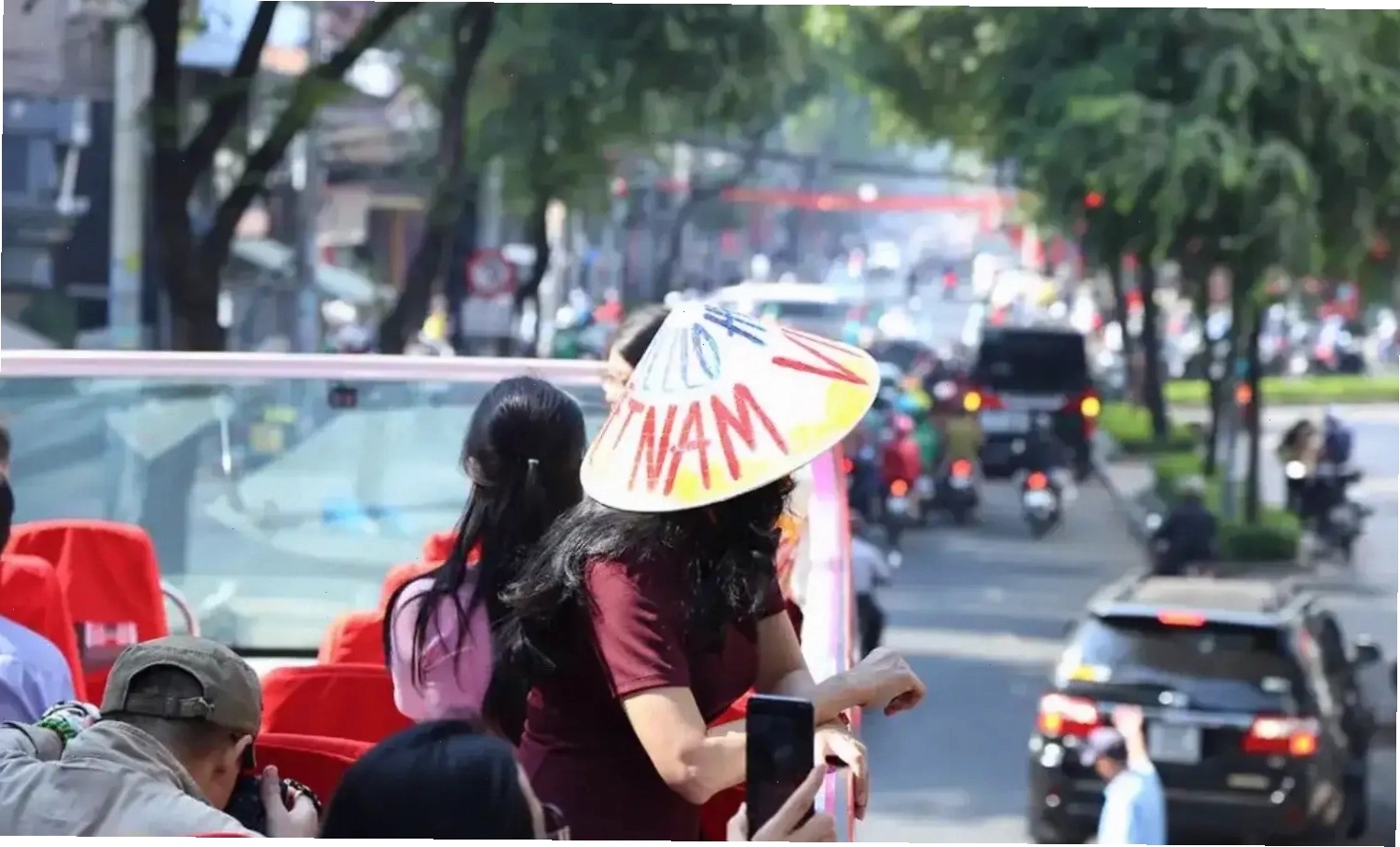 Xe buýt hai tầng màu đỏ di chuyển trên đường phố Sài Gòn